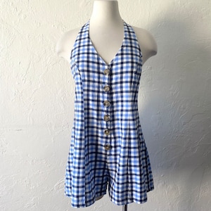 Puede incluir: Un mono azul y blanco de cuadros vichy con un estilo halter y cierre de botones en la parte delantera.