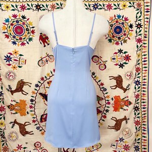 Peut inclure: Une robe courte bleu clair avec un d&eacute;collet&eacute; arrondi et des bretelles spaghetti. La robe a un corsage ajust&eacute; et une jupe l&eacute;g&egrave;rement &eacute;vas&eacute;e.