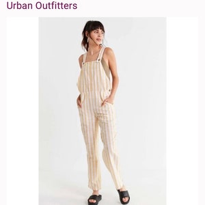 May include: White and yellow striped linen overalls with a square neckline and adjustable straps. The overalls have two front pockets and a relaxed fit.