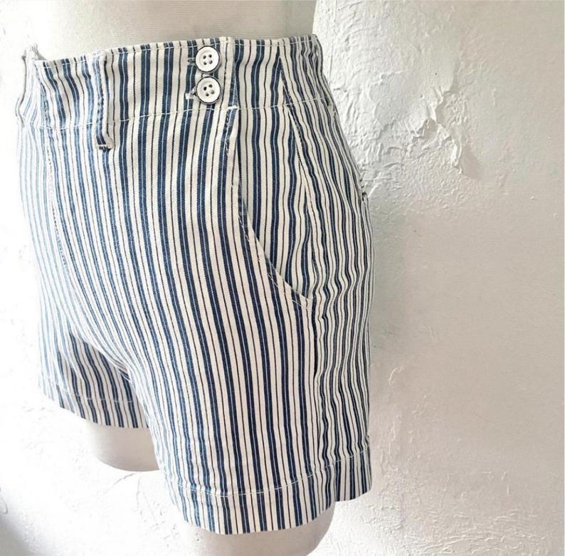 May include: White and blue striped high-waisted shorts with a button closure.