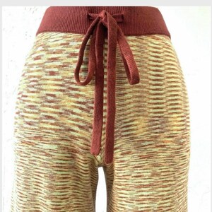 May include: Red and cream knit pants with a drawstring waist.