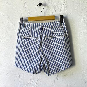 May include: Blue and white striped shorts with a high waist and pockets. The shorts are made of a lightweight fabric and have a relaxed fit.