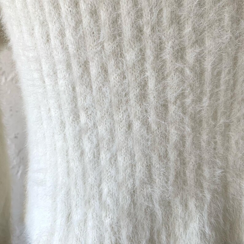 Peut inclure: Tissu en maille blanc et duveteux avec un motif textur&eacute;. Le tissu est doux et moelleux.