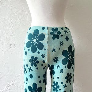 K&ouml;nnte beinhalten: Blaue Hose mit einem Blumenmuster mit dunkelblauen Blumen auf hellblauem Hintergrund.