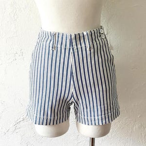 May include: White and blue striped shorts with a high waist and button closure. The shorts are made of a lightweight fabric and have a relaxed fit.