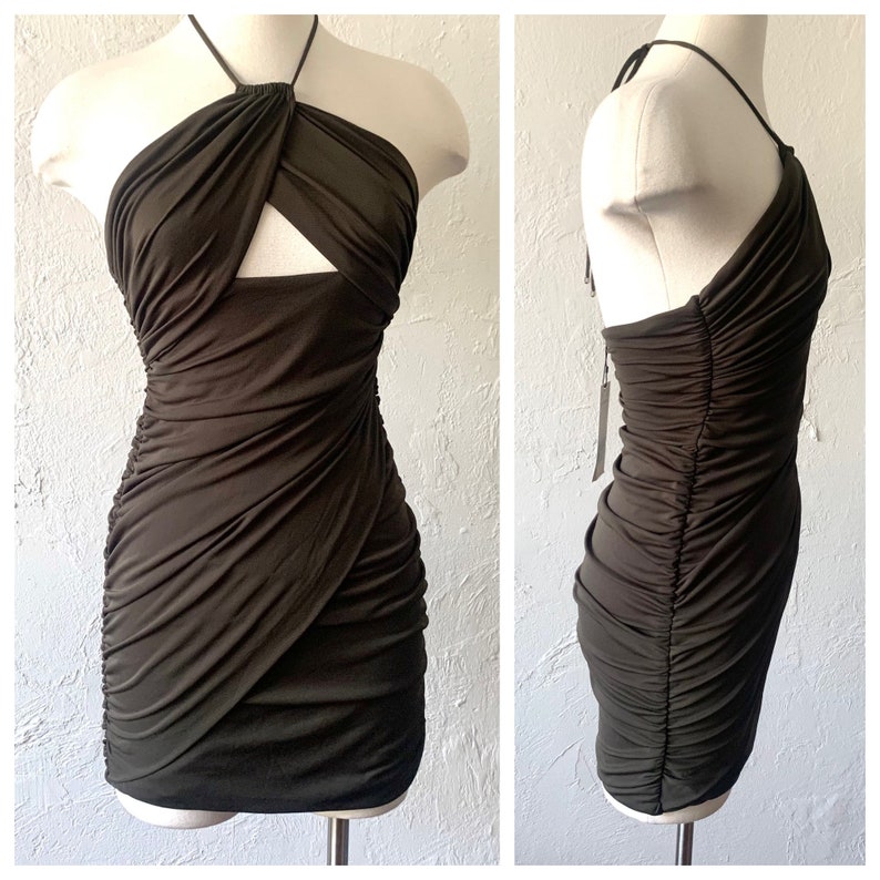 Puede incluir: Un vestido halter verde oscuro con un detalle de corte en el escote y un dise&ntilde;o fruncido. El vestido es ajustado y tiene una longitud corta.