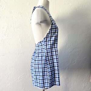 Puede incluir: Un vestido sin mangas de cuadros azules y blancos con cuello halter y lazada en la espalda.