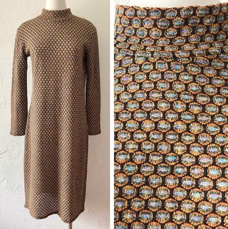 May include: A brown and gold patterned dress with a mock neck and long sleeves. The dress has a geometric pattern with a subtle shimmer.