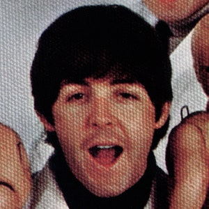 May include: A close-up of a man with dark brown hair and a black turtleneck. He is wearing a white shirt underneath the turtleneck and has a surprised expression on his face.