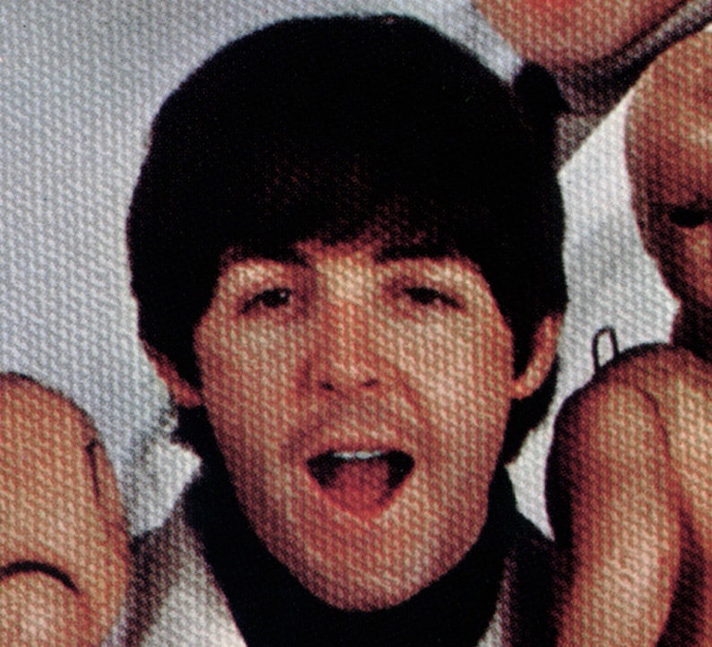May include: A close-up of a man with dark brown hair and a black turtleneck. He is wearing a white shirt underneath the turtleneck and has a surprised expression on his face.