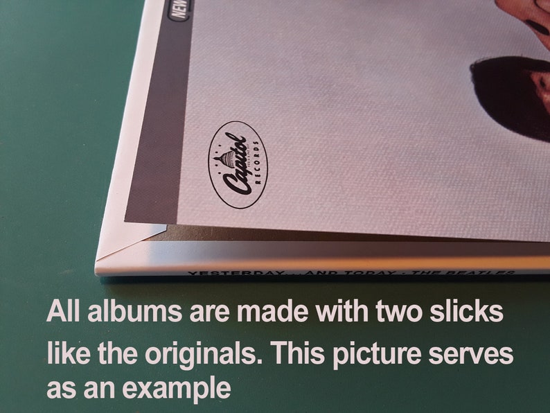 May include: Close-up of the spine of a vinyl record album. The album cover is white with a black and white photo of a person. The album is titled "Yesterday and Today" by The Beatles. The Capitol Records logo is visible on the spine.