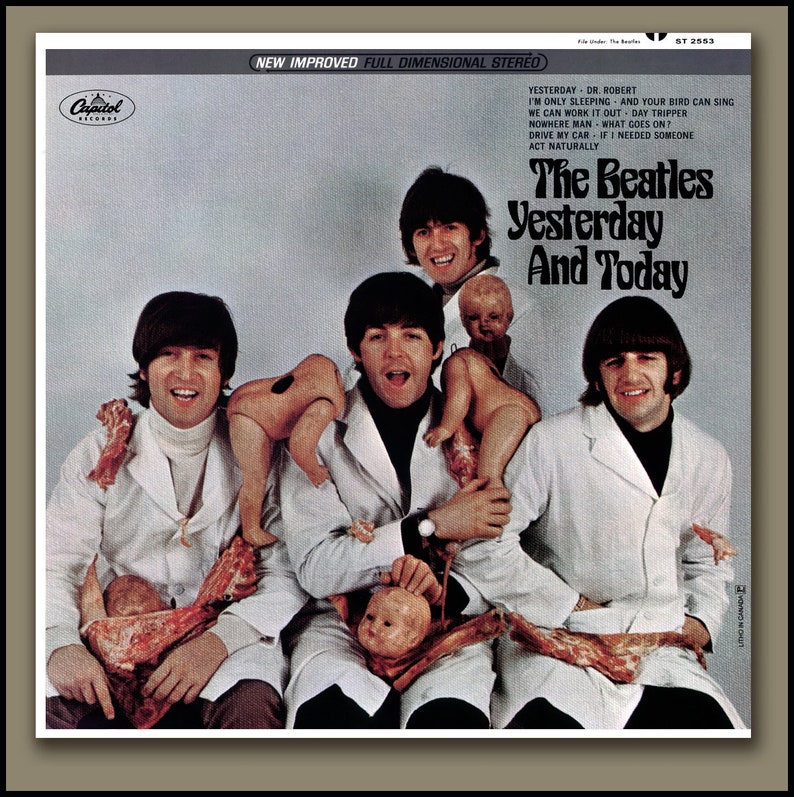 May include: The Beatles album cover for "Yesterday and Today" shows the band members wearing white lab coats, holding raw meat and baby dolls. The album title is printed in large, bold letters.