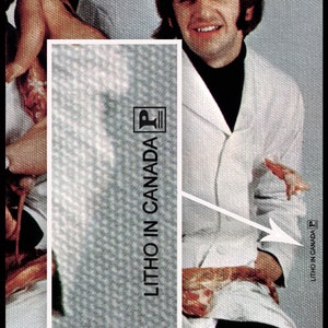 May include: A black and white photograph of a man wearing a white jacket with a black turtleneck. The text "LITHO IN CANADA" is printed on the jacket.