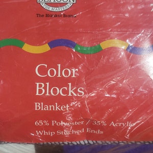 Puede incluir: Un paquete rojo para una "Manta Color Blocks" de "Beacon The Blanket Brand". La manta est&aacute; hecha de 65% poli&eacute;ster y 35% acr&iacute;lico con extremos cosidos a l&aacute;tigo. El paquete tiene un dise&ntilde;o ondulado colorido.