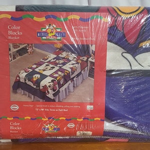 Puede incluir: Una manta empaquetada con un dise&ntilde;o colorido con Mickey Mouse y sus amigos. La manta est&aacute; etiquetada como "Color Blocks" y est&aacute; dise&ntilde;ada para una cama individual o de matrimonio, midiendo 183 x 229 cm. El embalaje incluye el logotipo de "Mickey's Stuff for Kids".