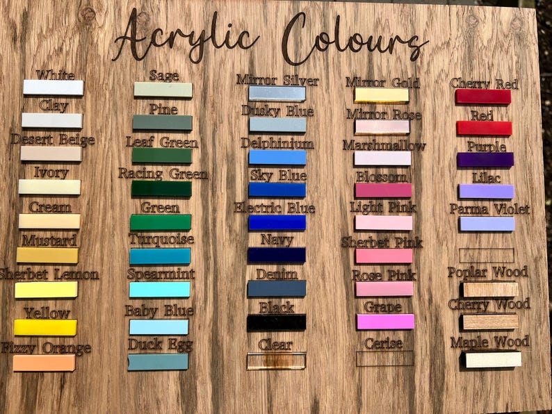May include: Wooden color chart labeled "Acrylic Colours" with color swatches in various shades like white, blue, green, and pink. Each color is labeled with its name, such as "Sky Blue" and "Cherry Red".