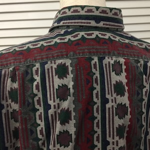 May include: A long-sleeved button-down shirt with a geometric pattern in shades of red, green, blue, and gray.