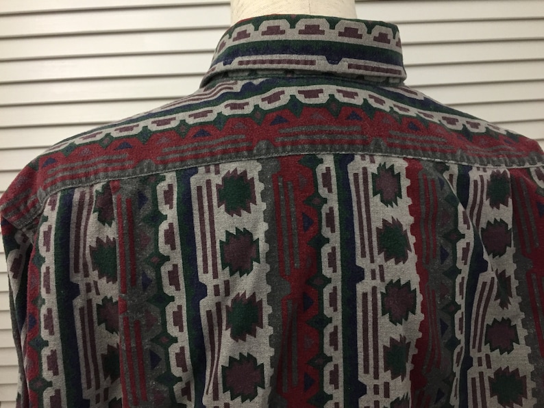 May include: A long-sleeved button-down shirt with a geometric pattern in shades of red, green, blue, and gray.