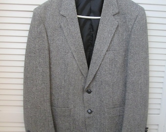 May include: A gray blazer with a subtle striped pattern. The blazer has two button closures and two pockets.