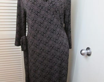 Klassieke vintage omslag jurk met veel rek. Zwart met zware donker lavendel patroon. Elastisch polyester tijdloze vleiende omslag jurk.