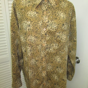 May include: A long-sleeved button-down shirt with a leopard print pattern. The shirt is made of a soft, comfortable fabric and has a relaxed fit.