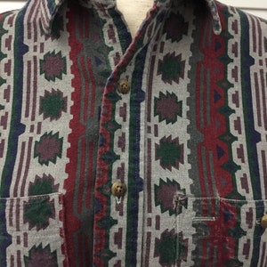 May include: A long-sleeved button-down shirt with a geometric pattern in shades of red, green, blue, and gray.