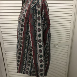 May include: A long-sleeved button-down shirt with a geometric pattern in shades of red, green, blue, and gray.
