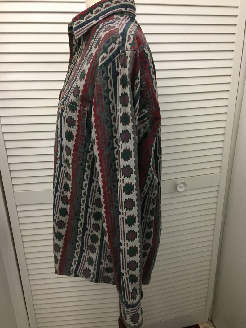 May include: A long-sleeved button-down shirt with a geometric pattern in shades of red, green, blue, and gray.