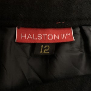 May include: A red label with the text "HALSTON III™" and a black label with the number "12" on a black fabric background.