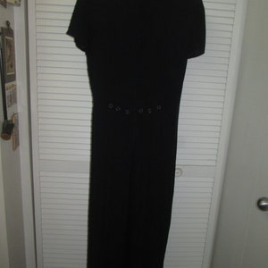 Vintage black jumpsuit with short sleeves and unique button details on front and back. Back zipper, Easy to shorten for current mod look.