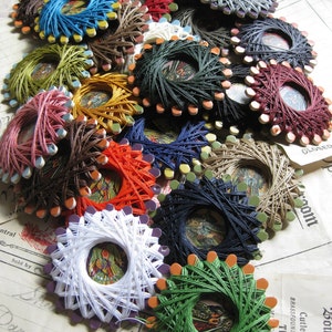 May include: A collection of colorful thread spools with different designs and patterns. The spools are arranged in a circular pattern and are made of wood and metal. The spools are used for sewing and embroidery.