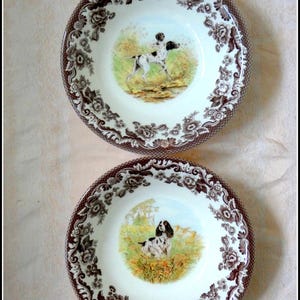 May include: A white ceramic mug with a black handle and the text "But First, Coffee" in a handwritten style. The mug is on a white surface. The mug is approximately 4 inches tall.