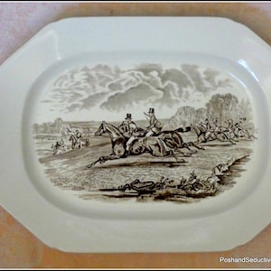 Puede incluir: Plato de servir octogonal color crema con una escena ecuestre en tonos sepia. La ilustración representa jinetes a caballo, corriendo por un campo, con árboles y nubes en el fondo. El plato tiene un acabado brillante y un borde decorativo.