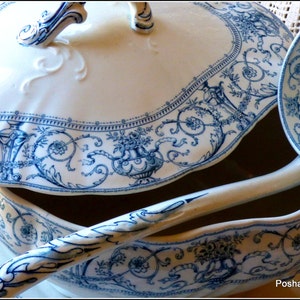 May include: A vintage blue and white porcelain soup tureen with a lid and a matching ladle. The tureen features a delicate floral design.