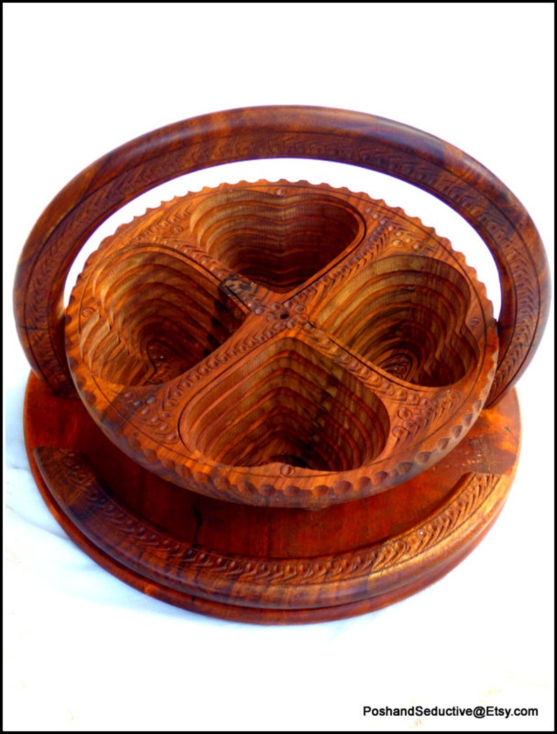 May include: A wooden serving tray with four heart-shaped compartments. The tray has a carved handle and intricate details.