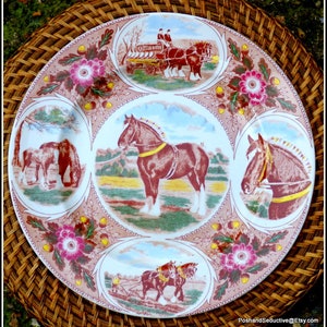 May include: A decorative plate featuring scenes of brown horses in oval vignettes, set against a floral and brown border. The vignettes show horses pulling a cart and plowing a field. The plate's colour scheme is brown and pink.