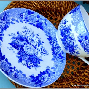 May include: A blue and white porcelain teacup and saucer set with a floral pattern. The set features a delicate floral design with blue flowers and leaves on a white background.