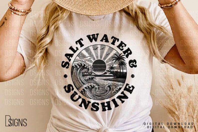 Pode incluir: Uma camiseta branca com um gr&aacute;fico circular preto que diz "Salt Water & Sunshine" com um sol, palmeiras e ondas dentro do c&iacute;rculo.