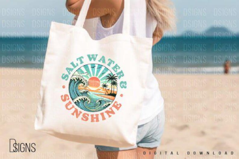 Pode incluir: Uma bolsa tote branca com um design gr&aacute;fico de um p&ocirc;r do sol sobre o oceano com ondas e palmeiras. O texto "Salt Water & Sunshine" est&aacute; escrito em um c&iacute;rculo ao redor do gr&aacute;fico.