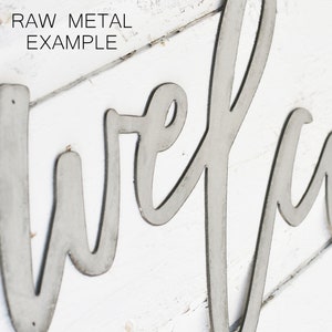 May include: A metal sign with the word "welcome" written in a cursive font. The sign is made of raw metal and has a rustic look.