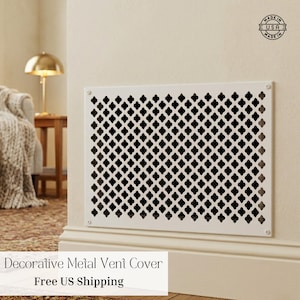 May include: A white decorative metal vent cover with a repeating quatrefoil pattern. The vent cover is rectangular and mounted on a beige wall. The text "Decorative Metal Vent Cover" is at the bottom.