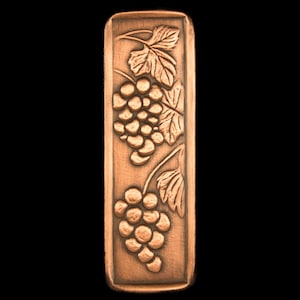 May include: A copper-colored rectangular plaque with an embossed design of grapes and leaves.