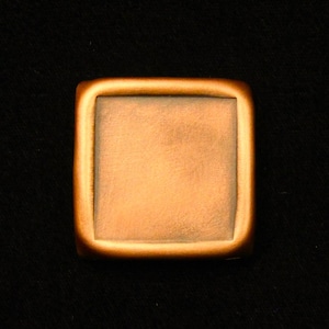 May include: A square-shaped, copper-colored metal plaque with a smooth, slightly textured surface.