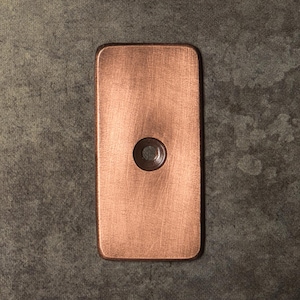 May include: A rectangular copper plate with a brushed metallic finish and rounded corners. The plate features a single, centered circular hole with a beveled edge, providing a clean and functional design element for various mounting or decorative applications.