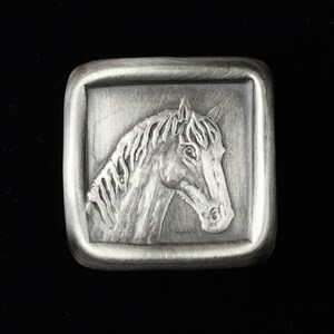 May include: Silver belt buckle with a detailed horse head design.