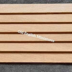 May include: A set of six wooden strips, each with a natural wood finish. The strips are arranged horizontally, creating a slatted effect. The strips are approximately 1/2 inch thick and 1 inch wide. The wood is smooth and has a light brown color.