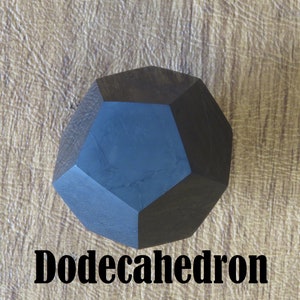 May include: A dark blue wooden dodecahedron, a twelve-sided geometric shape, on a light brown textured surface. The word "Dodecahedron" is written in black below the shape.