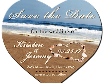Può includere: Annuncio di matrimonio a forma di cuore con sfondo di scena sulla spiaggia. Il testo "Save the Date" è in alto, con i nomi "Kristen & Jeremy" e la data "05.23.17". L'annuncio è per un matrimonio a Miami Beach, Florida.
