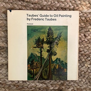 May include: A book titled "Taubes' Guide to Oil Painting by Frederic Taubes" with a painting of a forest scene on the cover. The painting features three tall trees, a mountain range in the background, and a bright yellow sky.