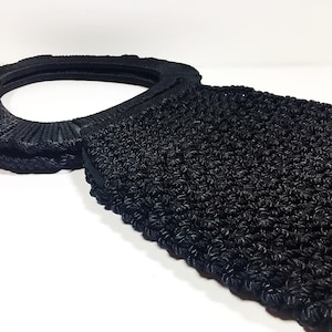 May include: Black crocheted tote bag with a large, round, black handle.